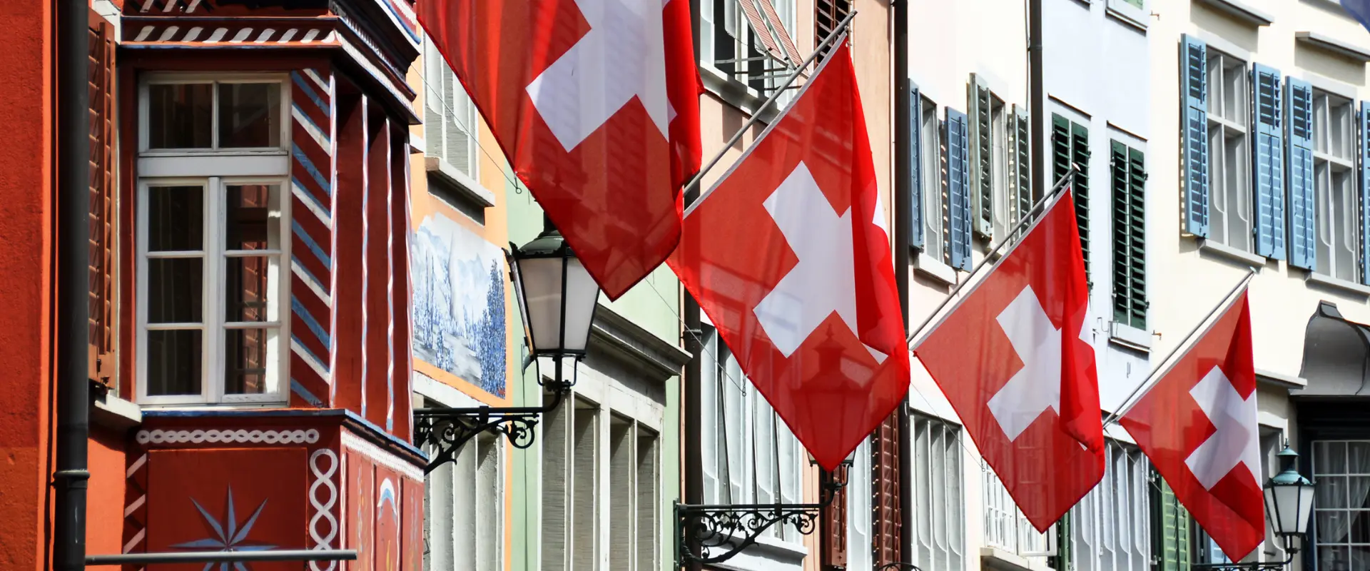 Swiss flags hanging off old buildings in Zurich Switzerland