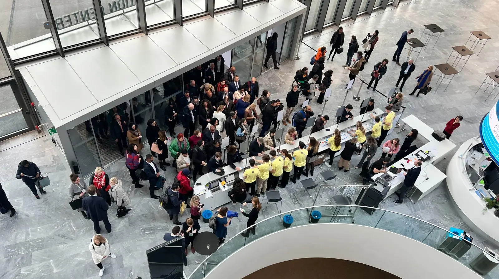 Delegates registering at the welcome desk during the WADA Annual Symposium at a modern conference venue.