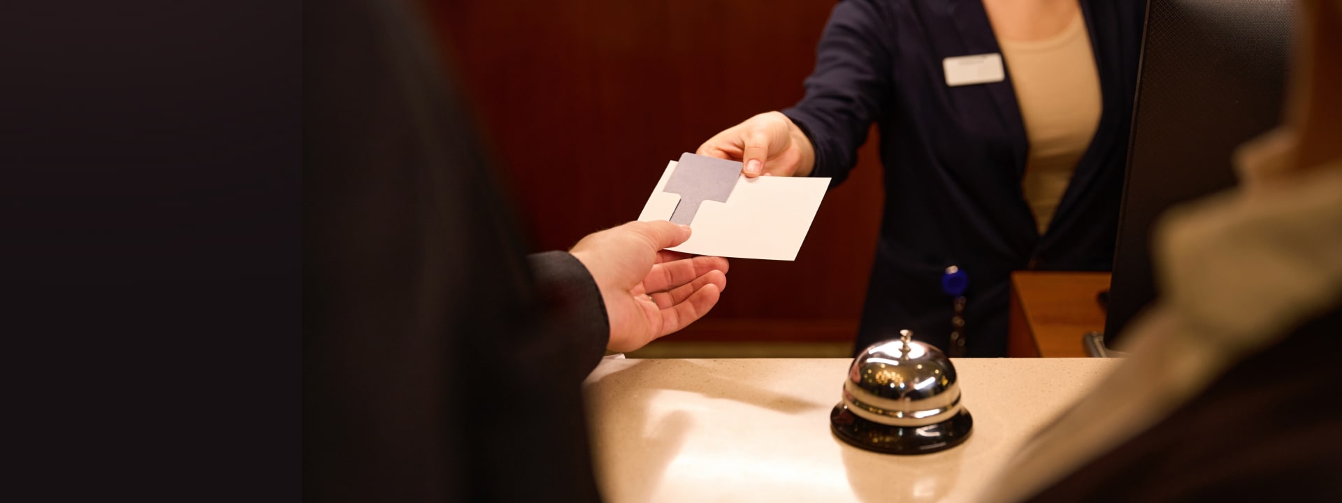 Receptionist passing a keycard to a guest in a hotel