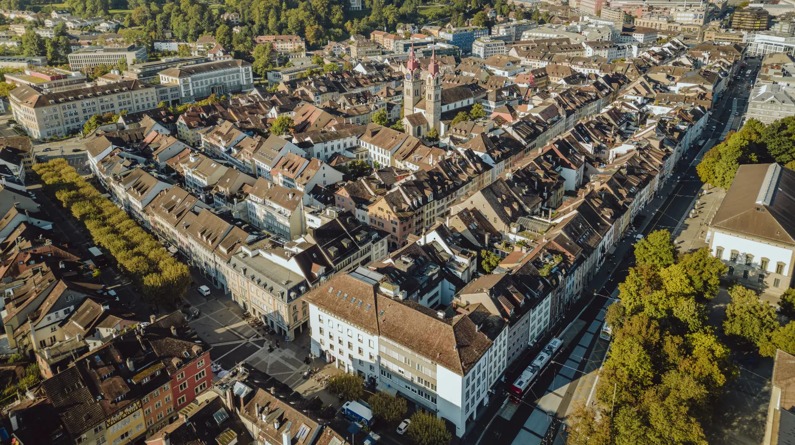 Aerial view of Winterthur city centre showing a dense grid of rooftops, streets and urban blocks stretching across the Swiss cityscape.