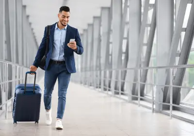 Business traveller walking through an airport with a suitcase