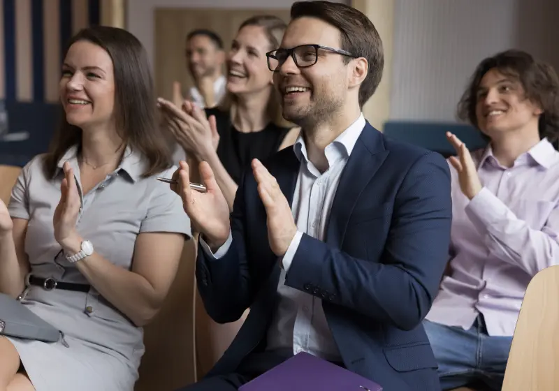 Conference attendees applauding during a professional congress presentation