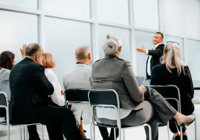 Speaker presenting a bid strategy to stakeholders in a meeting room