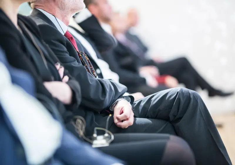Business professionals seated at a congress or conference session