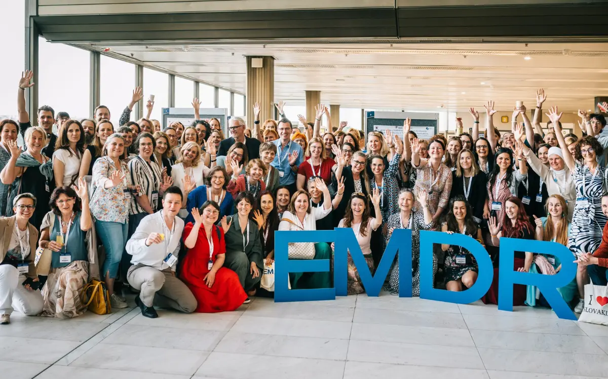 Group photo of congress delegates with EMDR letter props at the EMDR Europe 2025 in Prague