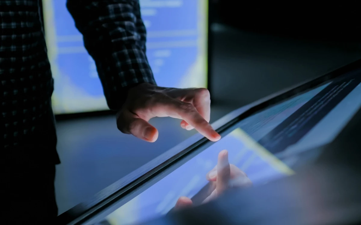 Education and technology concept - man using interactive touchscreen display of electronic kiosk 