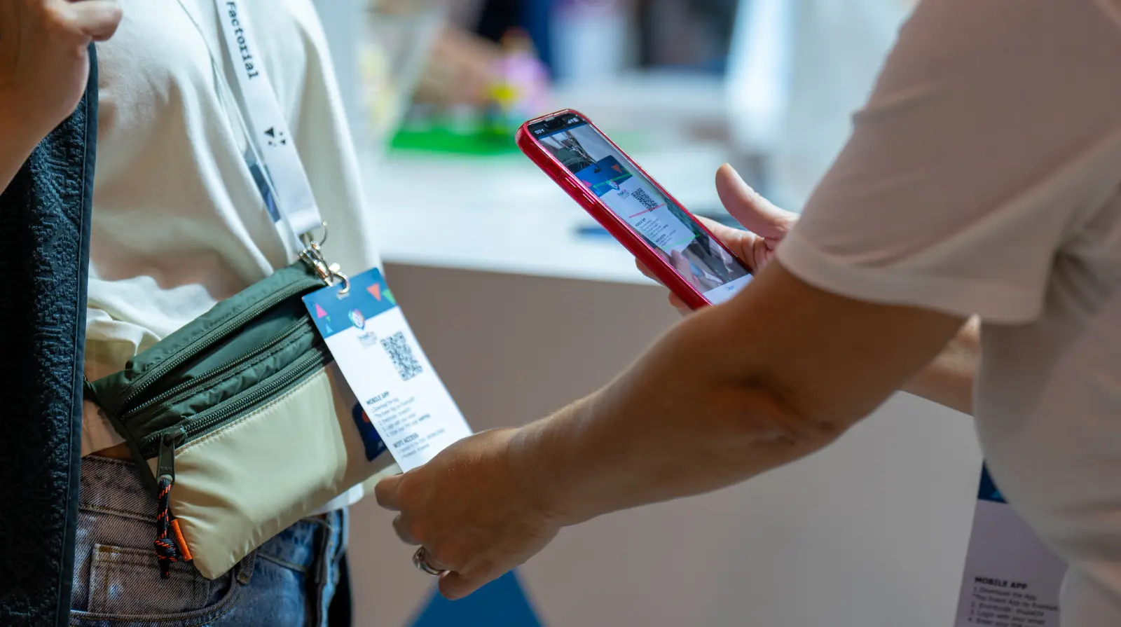 Delegate scans another attendee's QR-coded conference badge with a mobile phone at DrupalCon Europe, using the event app to exchange contact details.