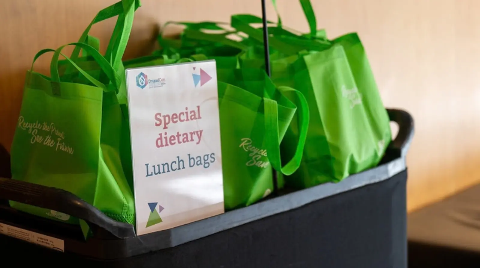A crate of green Special dietary lunch bags at DrupalCon Europe.