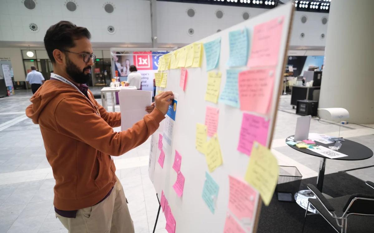 An organiser maps out a congress plan on a sticky-note board at an event venue.