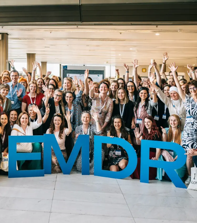 Group photo of congress delegates with EMDR letter props at the EMDR Europe 2025 in Prague