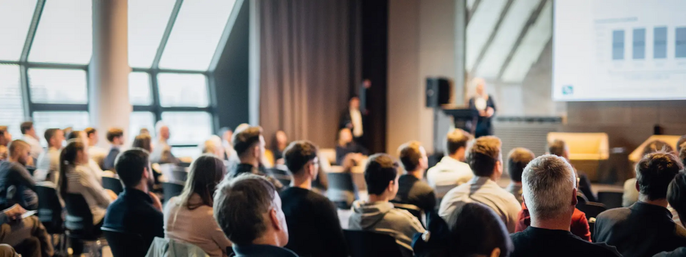 People sat in an auditorium listening to a speaker at a congress