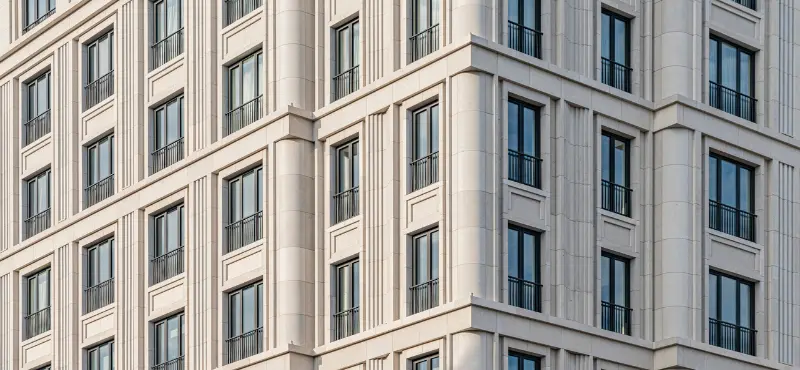 The stone facade and windows of a grand European congress hotel