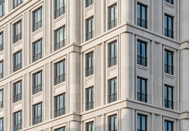 The stone facade and windows of a grand European congress hotel