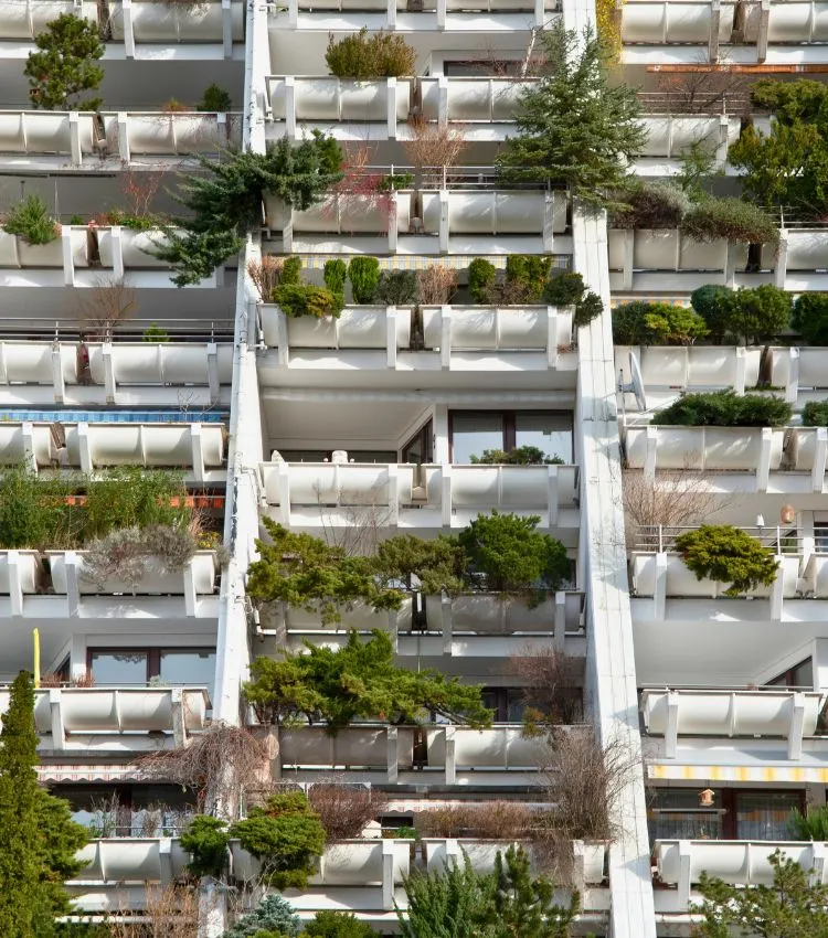 Modern residential building in Vienna featuring tiered balconies filled with plants and greenery, showcasing sustainable urban architecture and integrated vertical gardens.